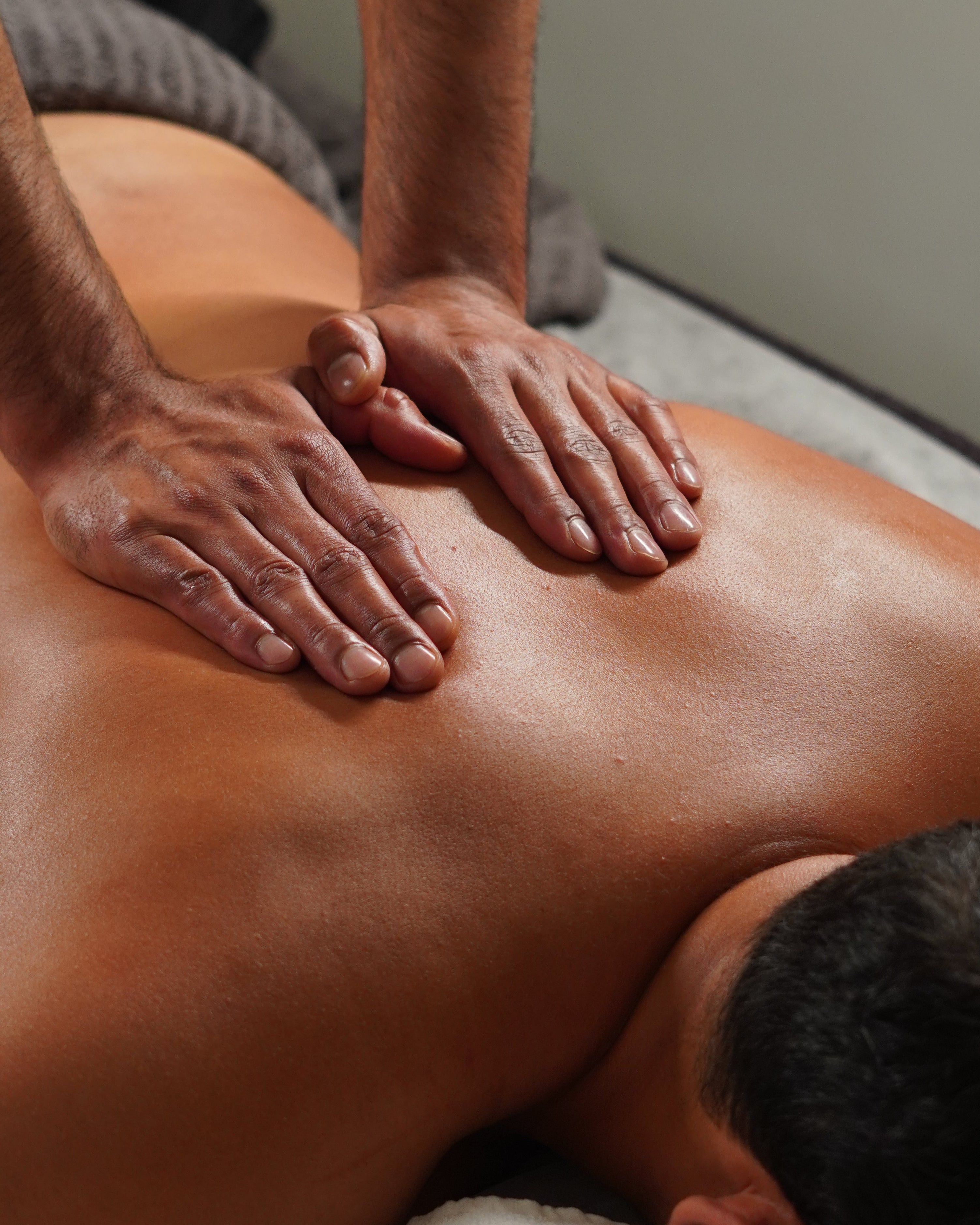 Person receiving a massage on a neutral background